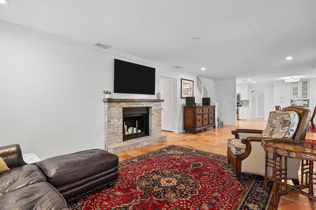 tiled living area with visible vents, a brick fireplace, crown molding, recessed lighting, and a textured ceiling