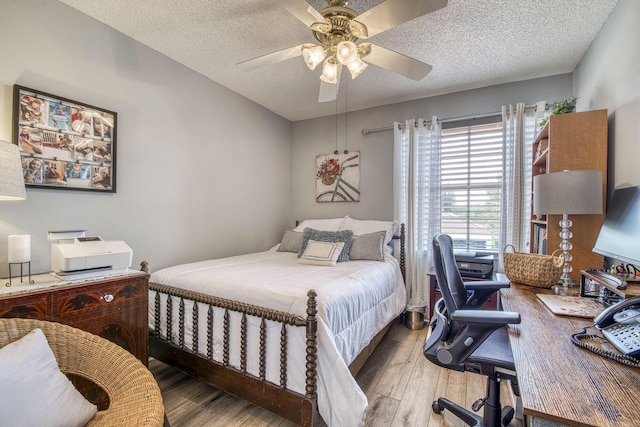 bedroom featuring a textured ceiling, a ceiling fan, and wood finished floors