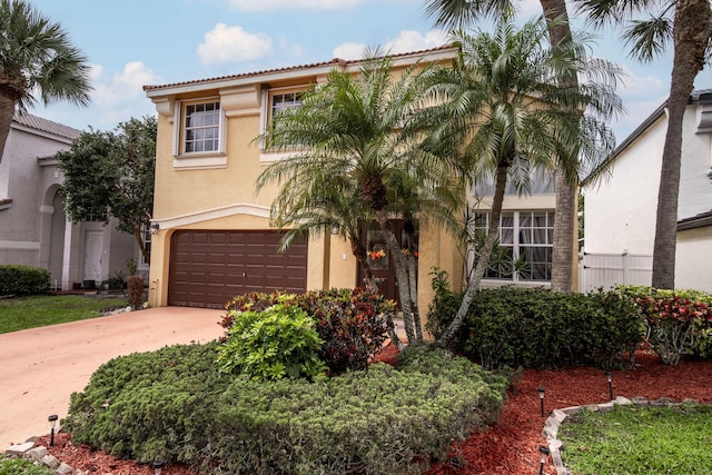 mediterranean / spanish house featuring stucco siding, concrete driveway, and an attached garage