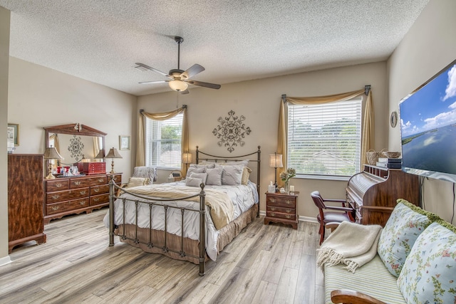 bedroom featuring ceiling fan, a textured ceiling, and wood finished floors