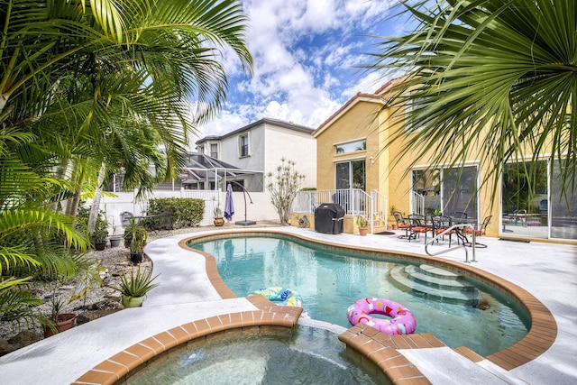 view of swimming pool featuring a patio area, a pool with connected hot tub, and a fenced backyard