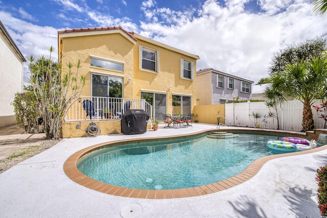 view of pool with area for grilling, a fenced in pool, a patio area, and fence