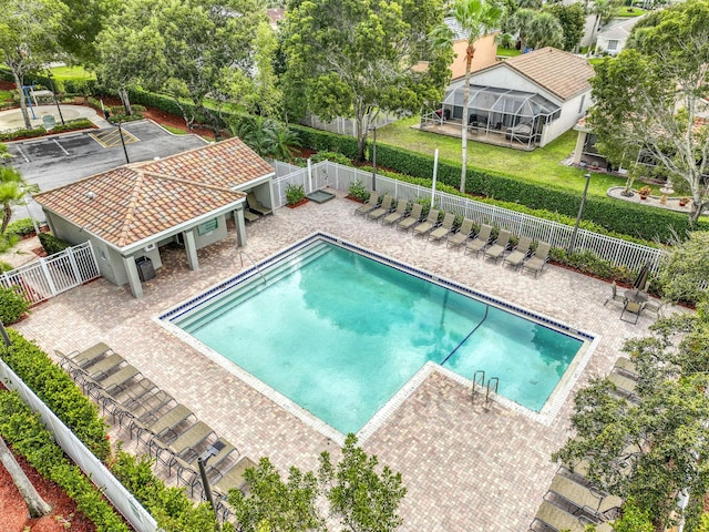 pool with a patio, a yard, and fence