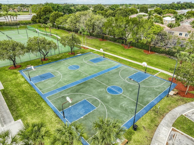 view of basketball court featuring community basketball court, a lawn, and fence