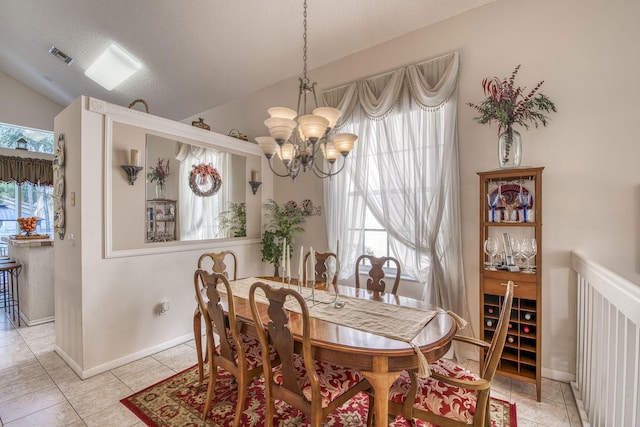 dining space with vaulted ceiling, light tile patterned floors, visible vents, and a chandelier