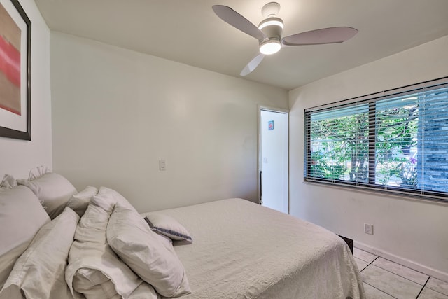 bedroom with light tile patterned flooring, baseboards, and a ceiling fan