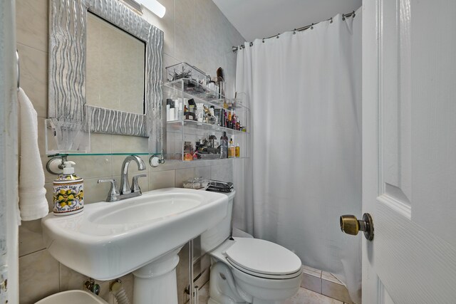 full bathroom featuring backsplash, toilet, tile walls, and a sink