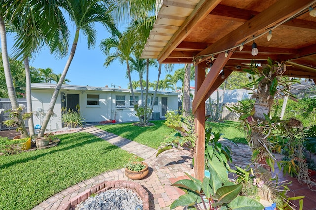 view of yard with cooling unit, fence, and a patio area