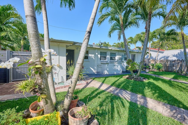 back of property featuring fence, a lawn, and stucco siding