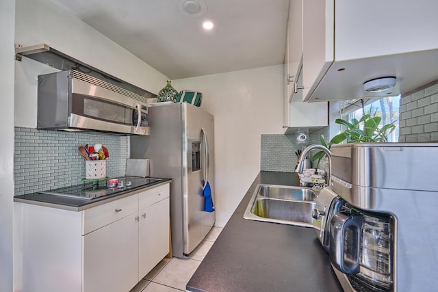 kitchen featuring white cabinetry, dark countertops, appliances with stainless steel finishes, and a sink