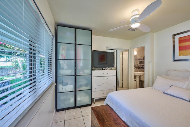 bedroom featuring light tile patterned floors, visible vents, ensuite bathroom, and ceiling fan