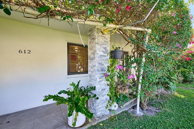 property entrance featuring stucco siding and stone siding