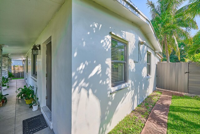 view of side of home featuring fence and stucco siding