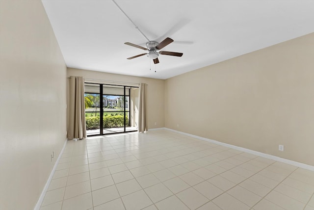 empty room featuring light tile patterned flooring, baseboards, and ceiling fan