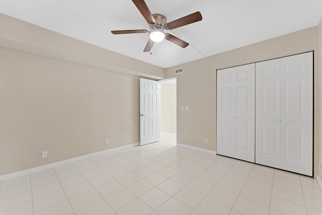 unfurnished bedroom with visible vents, a closet, light tile patterned flooring, baseboards, and ceiling fan