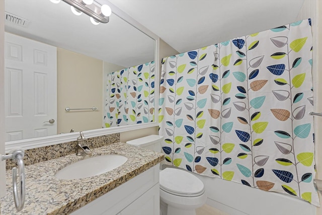 bathroom featuring visible vents, vanity, toilet, and shower / tub combo