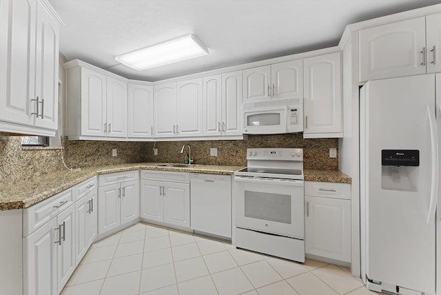 kitchen featuring a sink, backsplash, white appliances, white cabinets, and light stone countertops