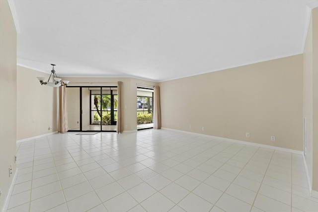 empty room featuring crown molding, a notable chandelier, light tile patterned flooring, and baseboards