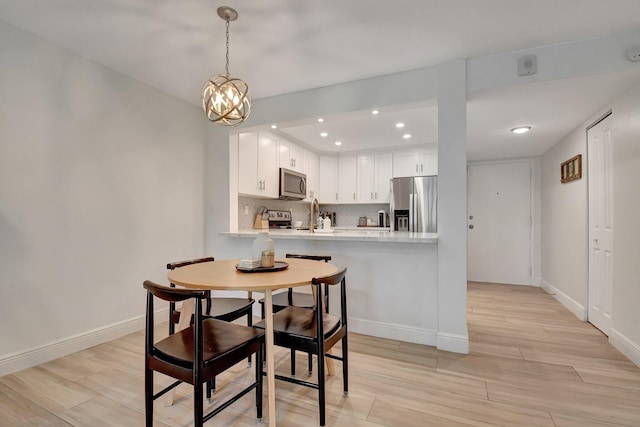 dining area with recessed lighting, an inviting chandelier, baseboards, and wood finish floors