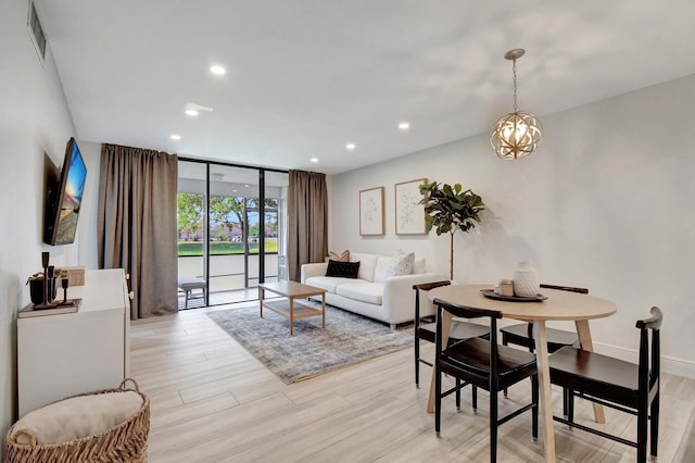 dining space featuring light wood finished floors, recessed lighting, a wall of windows, and baseboards