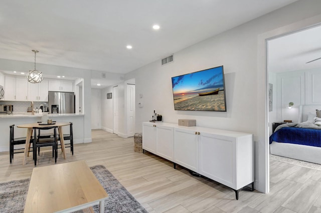 living area featuring recessed lighting, visible vents, baseboards, and light wood-style floors