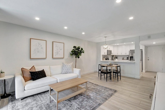 living area with recessed lighting, light wood-type flooring, and baseboards