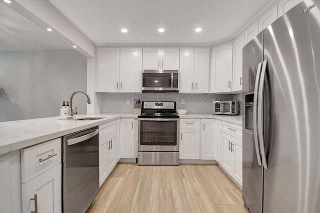 kitchen featuring white cabinets, appliances with stainless steel finishes, and a sink