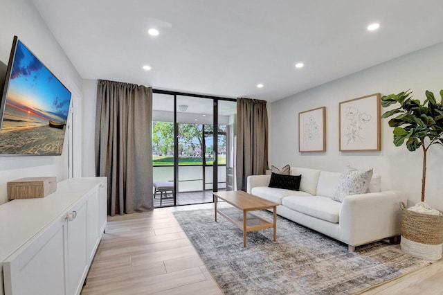 living area featuring recessed lighting, floor to ceiling windows, and light wood-style floors