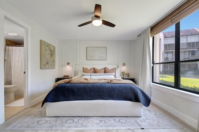 bedroom featuring multiple windows, wood finished floors, and baseboards