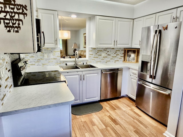 7185 Huntington Ln Unit 405, Delray Beach, FL 33446 - kitchen with appliances with stainless steel finishes, a sink, tasteful backsplash, light wood-type flooring, and white cabinetry