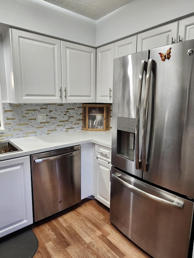 7185 Huntington Ln Unit 405, Delray Beach, FL 33446 - kitchen with appliances with stainless steel finishes, white cabinetry, light wood-style floors, light countertops, and a textured ceiling