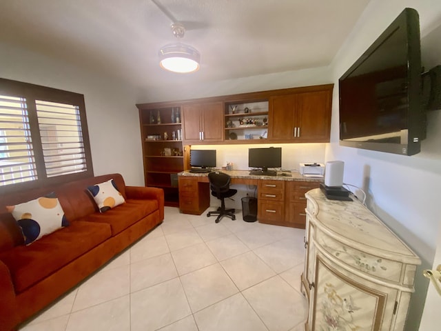 office with light tile patterned floors and built in desk