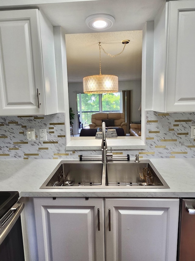 7185 Huntington Ln Unit 405, Delray Beach, FL 33446 - kitchen with light countertops, a sink, tasteful backsplash, white cabinets, and electric range