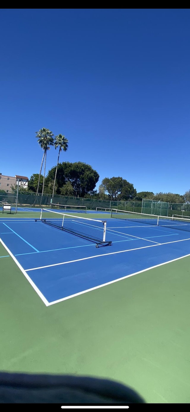 view of tennis court with fence