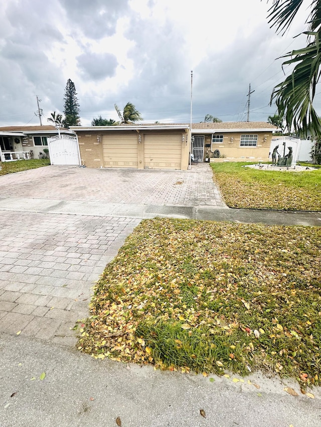 view of front facade featuring decorative driveway, a gate, an attached garage, and fence