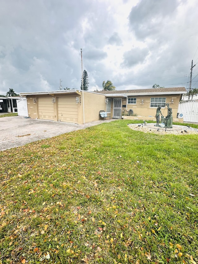 single story home with a front lawn, fence, and aphalt driveway