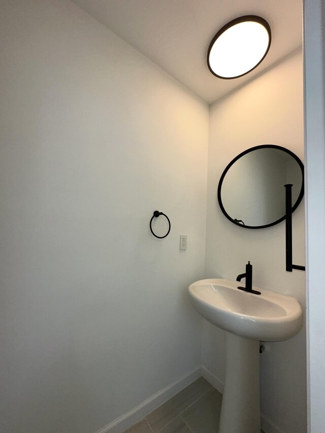 bathroom with baseboards and tile patterned flooring