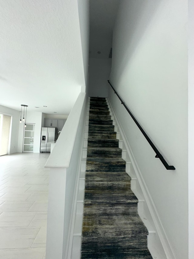 stairway featuring a textured ceiling