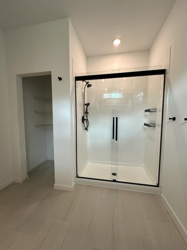 full bathroom with a stall shower and baseboards