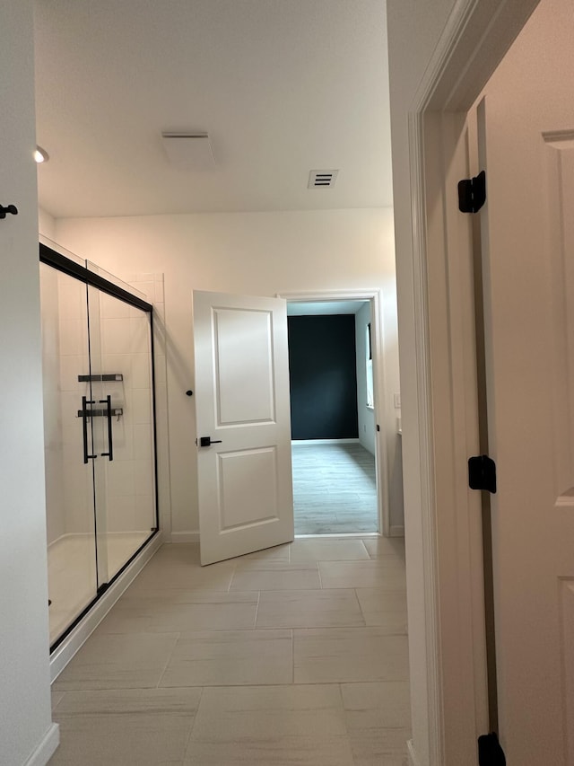 bathroom with baseboards, visible vents, and a stall shower