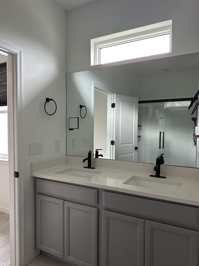 bathroom featuring a sink, an enclosed shower, and double vanity