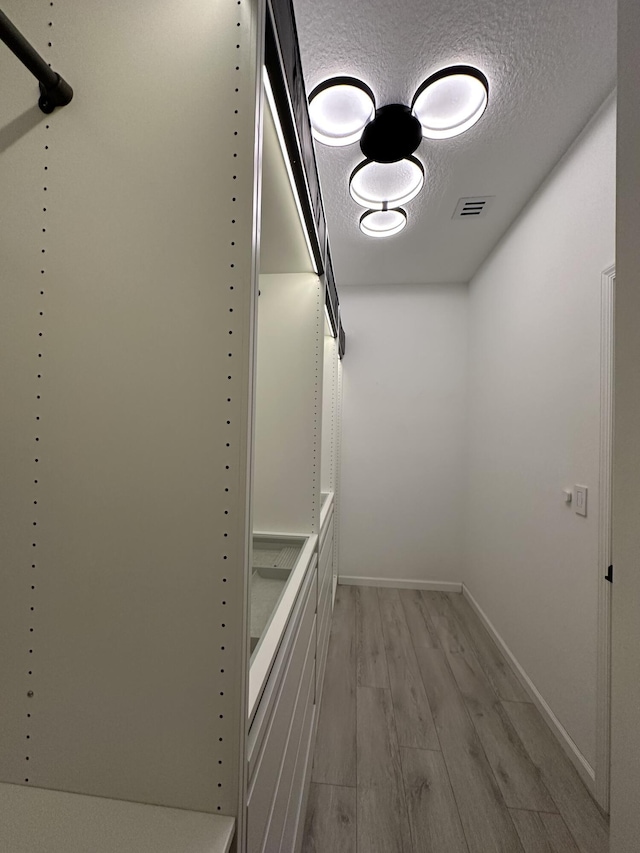 spacious closet featuring visible vents and light wood-type flooring