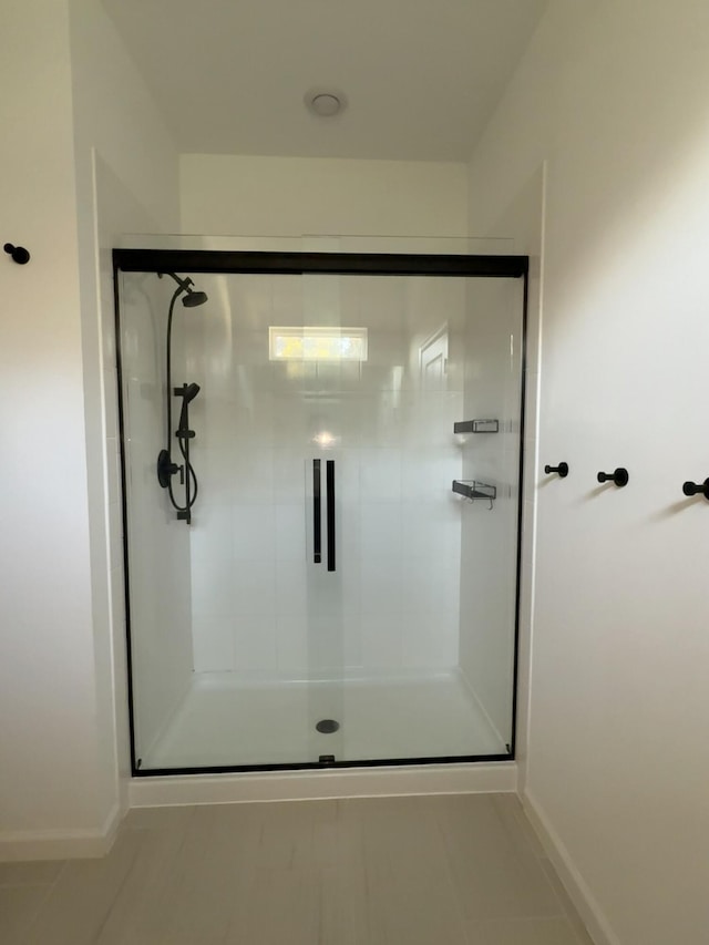 full bathroom with baseboards, a stall shower, and tile patterned flooring