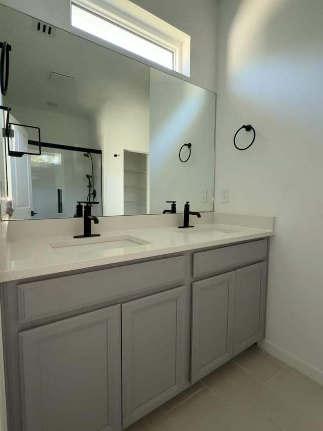 full bathroom featuring a shower stall, double vanity, and a sink