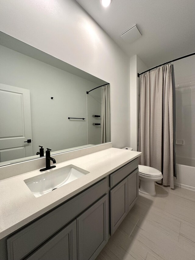 full bathroom with shower / bathtub combination with curtain, toilet, and vanity