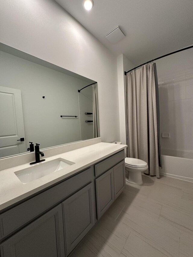 bathroom featuring shower / tub combo, toilet, and vanity