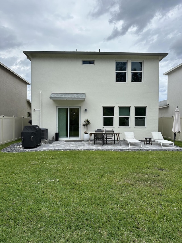 rear view of house featuring a yard, a patio, cooling unit, and fence