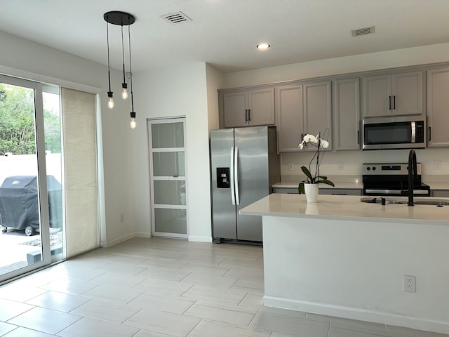 kitchen featuring visible vents, light countertops, gray cabinets, appliances with stainless steel finishes, and a sink