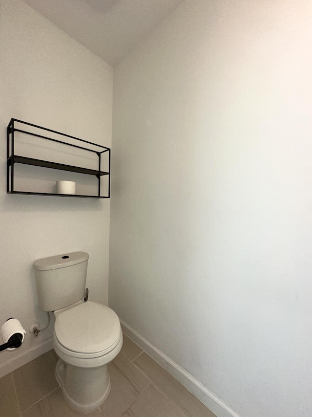 bathroom with toilet and baseboards