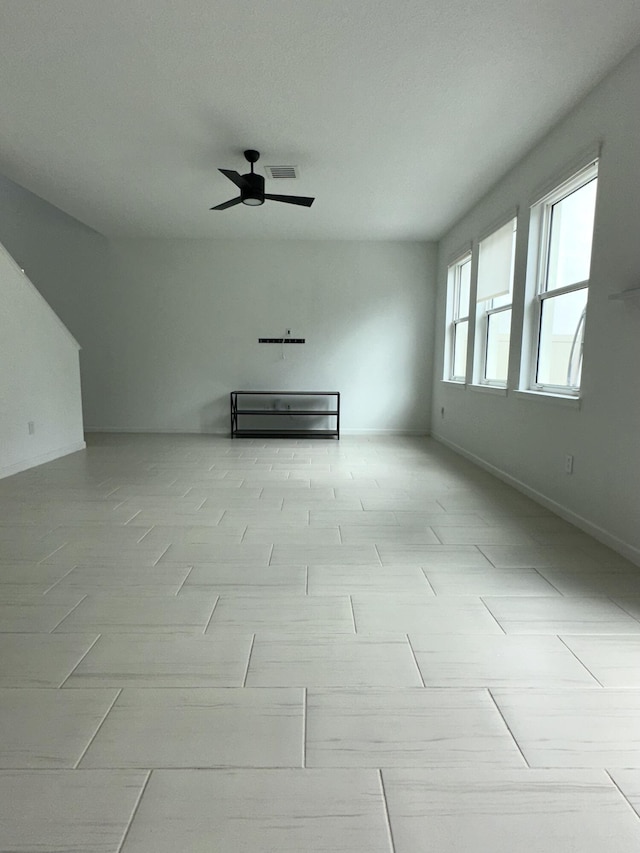 unfurnished living room with a ceiling fan and visible vents